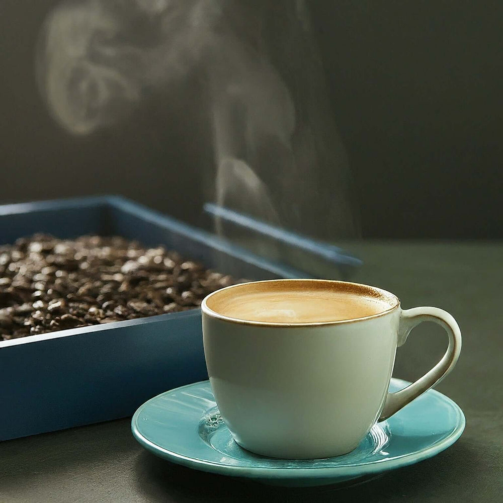 
                      
                        Steaming cup of Gourmet Fancy Tanzania coffee with coffee beans in the background.
                      
                    